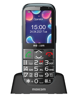 Telefon Telefon Maxcom MM724, cu butoane, privit din fata pe suportul de incarcare, cu imagine de fundal cu bule colorate